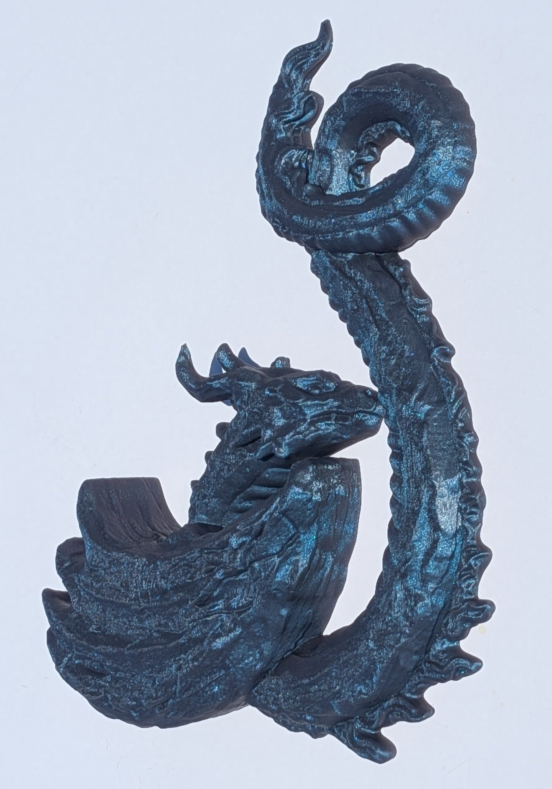 A dark metallic blue dragon figurine with a textured, weathered finish, shown against a plain light gray background.