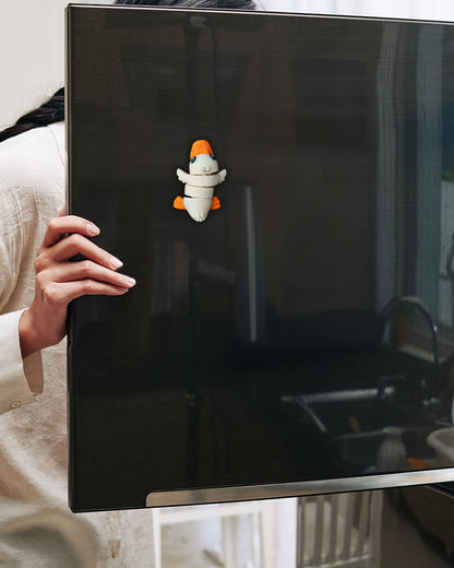 Person holding a black screen with a small toy figure on it