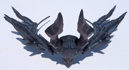 A dark metallic fantasy horned helmet or headpiece displayed on a plain white background, viewed from a top-down angle.