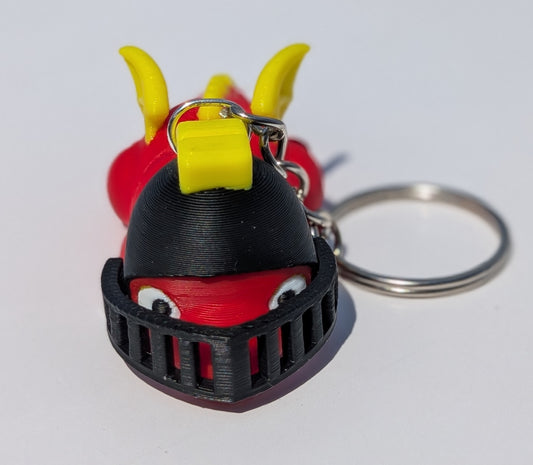 A 3D-printed keychain shaped like a red and black monster or creature with yellow horns, attached to a silver metal key ring on a plain white background.