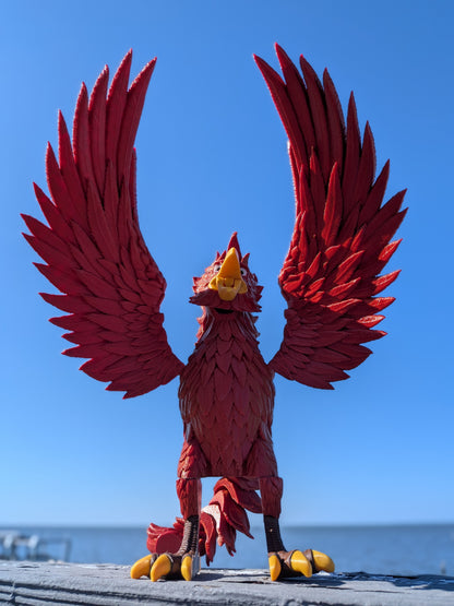 Articulated phoenix figure displayed outdoors with wings folded