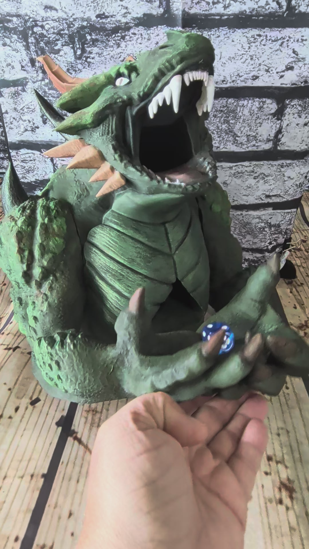 Hand-painted green devourer dice tower with open jaws and claws in its lap