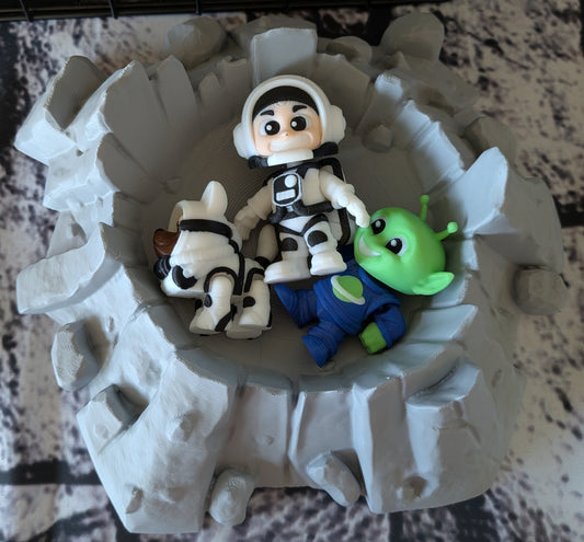 Moon crater fidget bowl with astronaut, dog, and alien figures inside