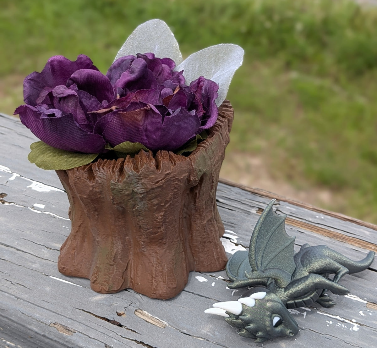 Dragon stump planter, front view with purple flower arrangement